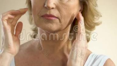 女人用手指在脸上拉扯下垂的皮肤，想着整容
