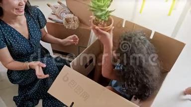 幸福混血儿家庭打开拆箱纸箱包裹，讨论搬迁后的室内设计装饰