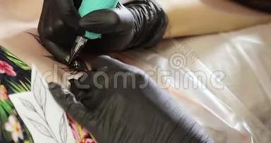 纹身师大师用纹身机在皮肤上画叶子的特写。