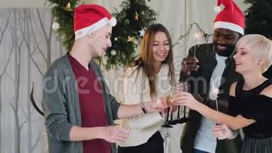 朋友们在一个白色的房间里庆祝<strong>新年</strong>，在一棵<strong>美</strong>丽的<strong>圣诞</strong>树旁边有<strong>圣诞</strong>装饰品。 吸引力