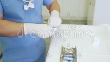穿无菌衣服和手套的贴身医生在手术前准备医疗器械