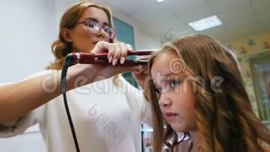 发型师是为小可爱女孩卷发，使用电动卷发熨斗。 关门