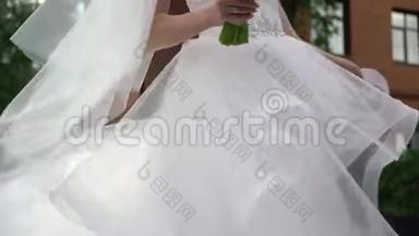年轻的新娘穿着婚纱在一个城市盘旋。 白色豪华礼服