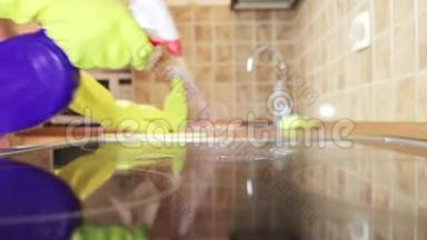 用除脂剂喷雾剂和一名戴黄色橡胶手套的妇女用吸尘器清洁<strong>厨房</strong>灶台烹饪<strong>面板</strong>