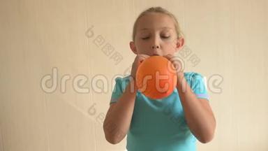 穿蓝色t恤的快乐女孩在家里的浴室里充气了一个明亮的橙色球。 浅淡的焦点