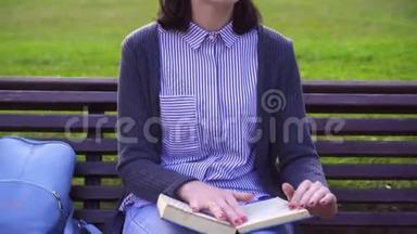 有视力障碍的女孩在长凳上为视力障碍者读一本书的肖像