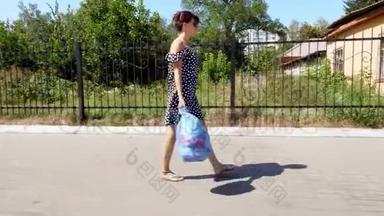 一个戴太阳镜的漂亮女孩手里拿着一包垃圾，扔垃圾。 <strong>夏日炎炎</strong>