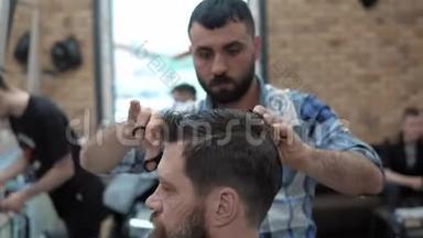 理发店的理发师用剪刀剪头发。 理发师在工作过程中`手。 理发师