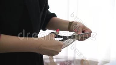 无法辨认的女人用剪刀剪彩，在圣诞节时包装礼物