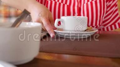 女人把糖立方体放进茶杯里。 咖啡店，女人`手拿着茶杯。 把糖块捡起来