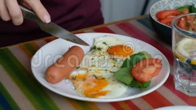 吃早餐的女人。 刀叉在手.. 美式早餐，包括煎鸡蛋、香肠、沙拉和烤面包。