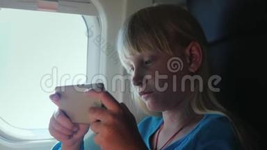 一个金发女孩<strong>坐飞机</strong>在智能手机上玩