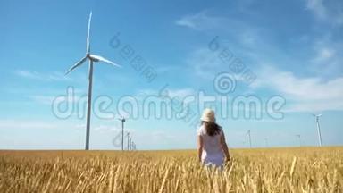 美丽的女孩走在黄色的麦田上，用<strong>风车发电</strong>