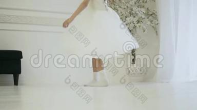 一个穿着优雅的白色连衣裙的女孩在舞蹈中旋转