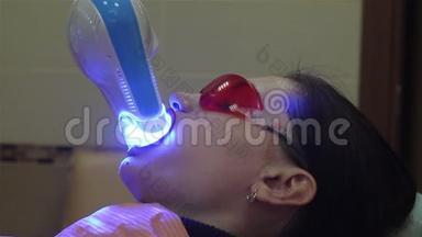 年轻女子在牙科医生办公室用紫外线`机器进行紫外线<strong>美白</strong>.