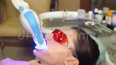 年轻女子在牙科医生办公室用<strong>紫外线</strong>`机器进行<strong>紫外线</strong>美白.