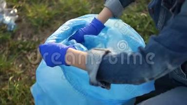 特写一个志愿者手收集垃圾的蓝色大塑料袋.. 废物分类、环境概念