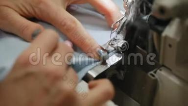 女人`手在缝纫机上缝一把锁。 缝纫机上的锁缝。 自动缝纫机。