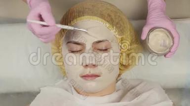 美容师把<strong>面膜敷</strong>在问题皮肤上。 年轻女子有皮肤清洁程序。 4K