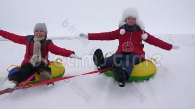 快乐的孩子们玩着雪碟，在<strong>冬天霜冻</strong>的日子在下雪的<strong>冬天</strong>的路上笑。 年轻人玩雪橇