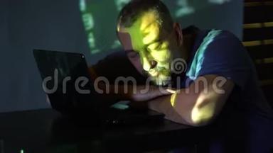 一个黑屋子里的黑客在电脑旁睡着了。使用程序代码。网络犯罪的概念。