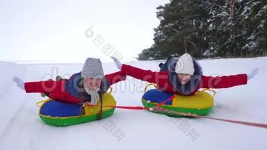 快乐的孩子们玩着雪碟，在<strong>冬天霜冻</strong>的日子在下雪的<strong>冬天</strong>的路上笑。 年轻人玩雪橇