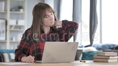 颈部疼痛的休闲少女在笔记本电脑上工作