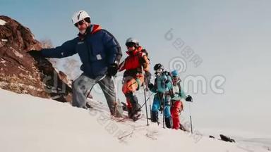 经验丰富的登山者和他训练有素的团队全副武装地在雪山上。 他有特别的钩检