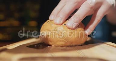 曼斯手把夹着芝麻的汉堡包切成两半，<strong>放在木板上</strong>。 慢动作