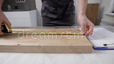 在工人手`的框架内.. 连接件在木板上<strong>标注</strong>尺寸.. 使用卷尺和铅笔