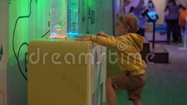 小男孩参观一个儿童科学博物馆。 他把气泡注入<strong>粘稠</strong>的液体