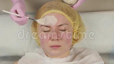 美容师把<strong>面膜敷</strong>在问题皮肤上。 年轻女子有皮肤清洁程序。 4K