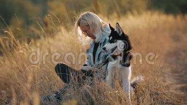 女人和狗在大自然中玩耍。 与宠物一起享受夏日时光。