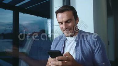 快乐的男人看手机。 帅哥在手机上看照片。