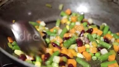 一个人<strong>用勺子把</strong>蔬菜混合物混合在一个深锅里的沸水中。
