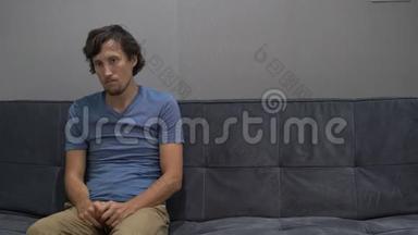一个年轻人坐在沙发上，感到沮丧、沮丧和恐惧。 右侧复制空间