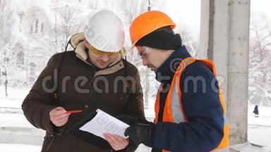 工程师视察冬季施工现场，与工长讨论问题。