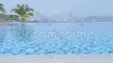 在蓝海和城市全景背景下度假酒店的豪华无限游泳池。 豪华酒店提供游泳池，可观看