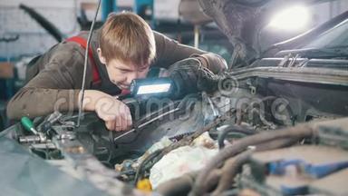 机械师检查和修理汽车发动机，汽车修理，在车间工作，大修，在引擎