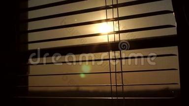 窗后日出百叶窗和蚊帐.. 窗户百叶窗后面的太阳。