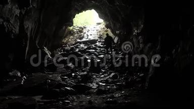 旅行者潜入洞穴。 库存录像。 旅行者探索洞穴隧道下绳。 危险洞穴隧道