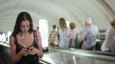 在地铁或地铁的自动扶梯上美丽的女人在电话中微笑