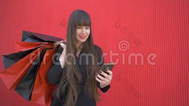 购物时间，年轻的快乐女孩在网上购物，使用智能手机，手里拿着<strong>红包</strong>
