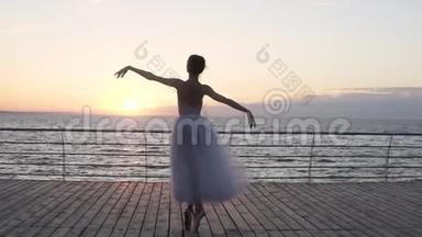 年轻漂亮的芭蕾舞演员在她的尖角芭蕾舞鞋上优雅地跳舞，她`在旋转。 她`穿着白色的图图