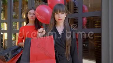 黑色星期<strong>五</strong>，严肃的女孩的肖像，展示了很多纸袋，在女友面前<strong>买</strong>东西，在黑暗中带着气球