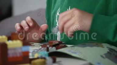 孩子们`手拿着一块乐高积木玩，双手合拢。 乐高是一种流行的建筑玩具