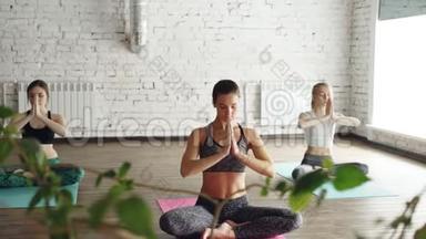 年轻的精神女孩正在瑜伽工作室做放松呼吸练习。 他们正在做泥地，然后