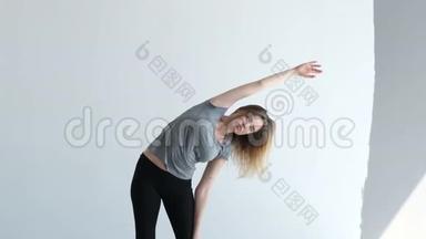 年轻的运动女孩在健身运动和慢动作舞蹈课前伸展双手