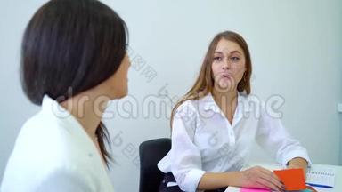 两名女高中生坐在教室里接受谈话辅导