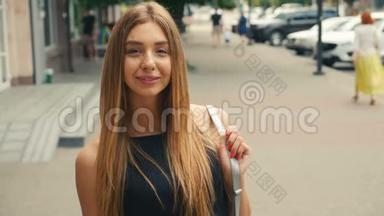 棕色头发的年轻女子的肖像，看着相机的稳定镜头。 城市街道上的肖像美女